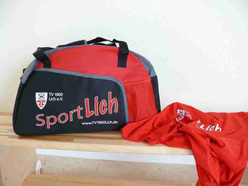 Schwarze Sporttasche mit roten Akzenten und einem roten T-Shirt daneben, beschriftet mit "SportLich".